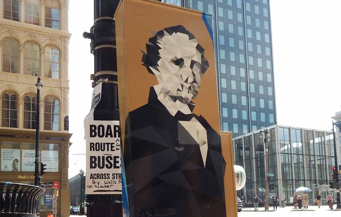 A portrait of Solomon Juneau on a utility box mural.