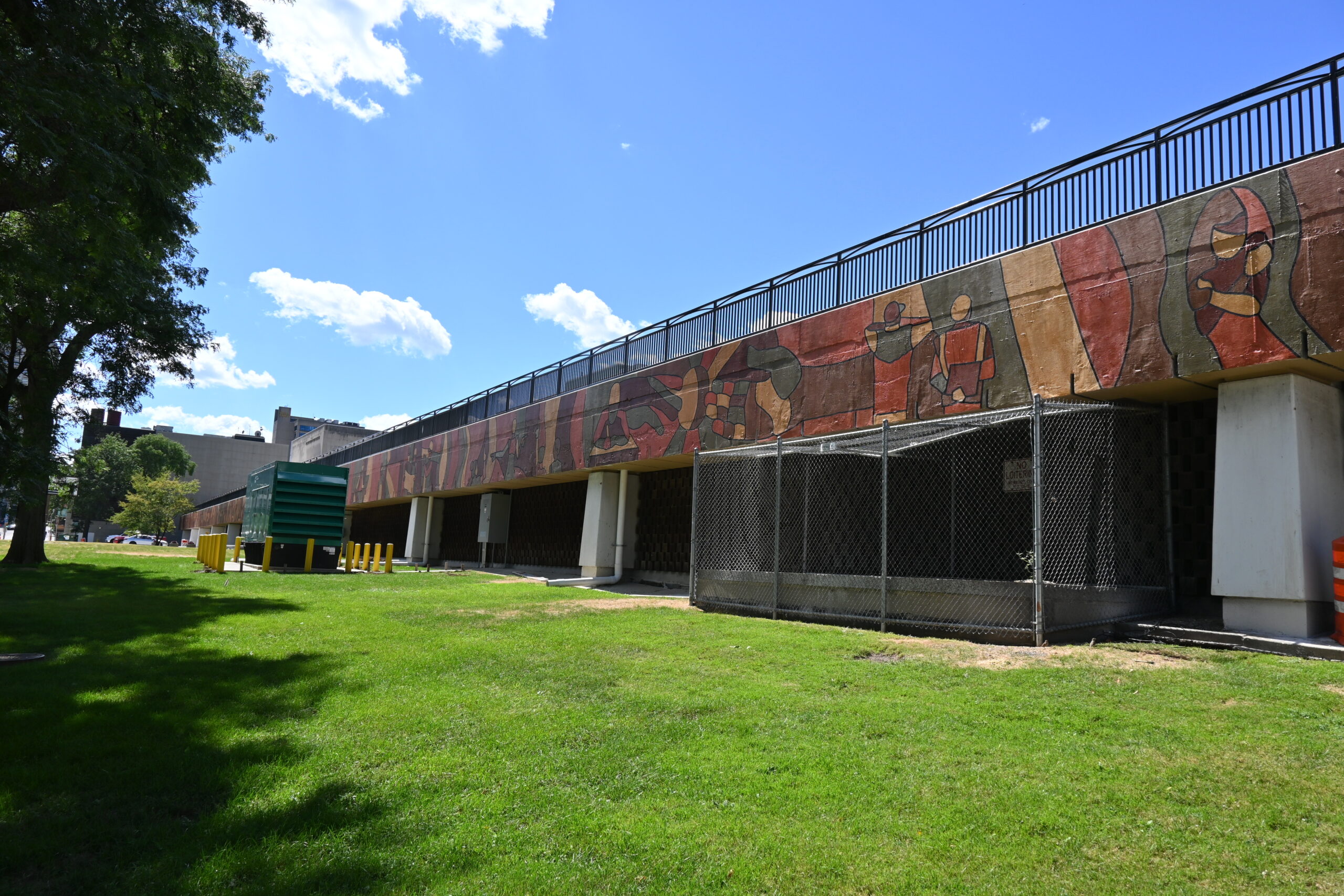 The Hero in You mural in summer with green grass in front of it.