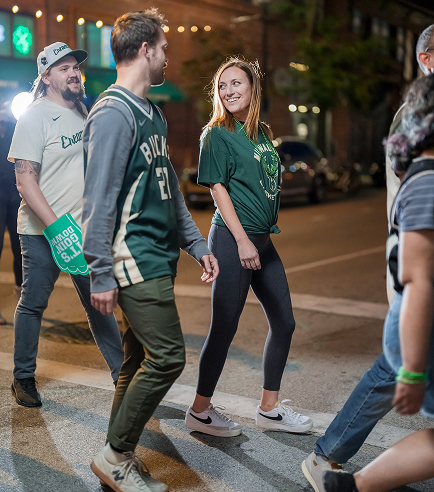 A group of Milwaukee Bucks fans cross the street.
