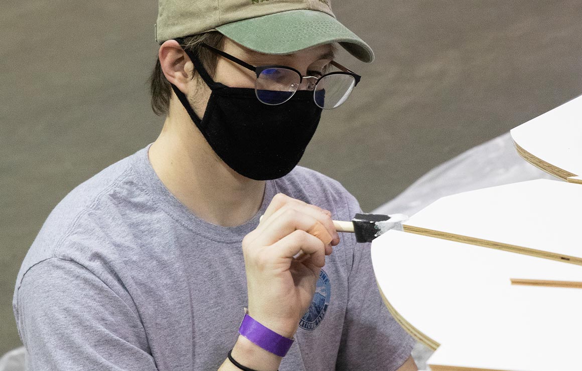 One artist paints a piece of the sculpture.