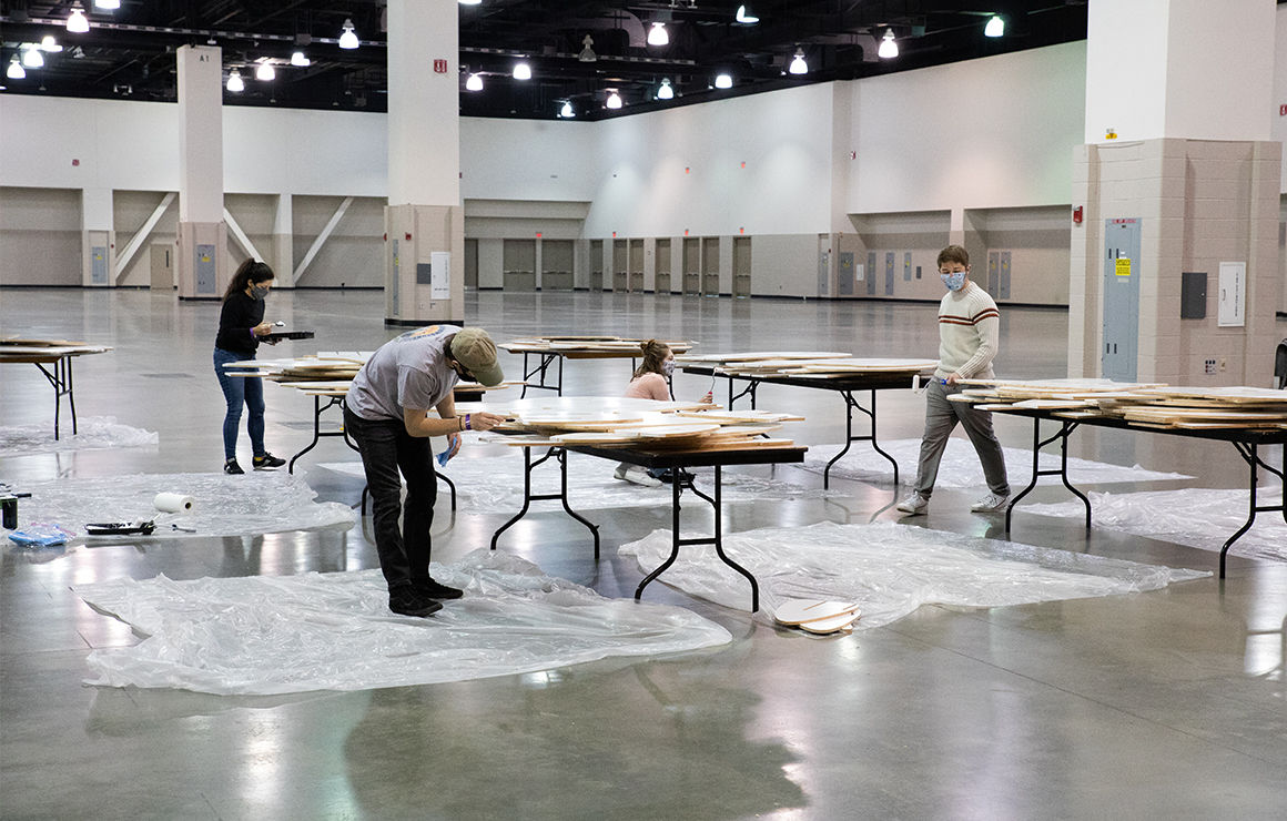 Artists assembling Massimals in a warehouse.