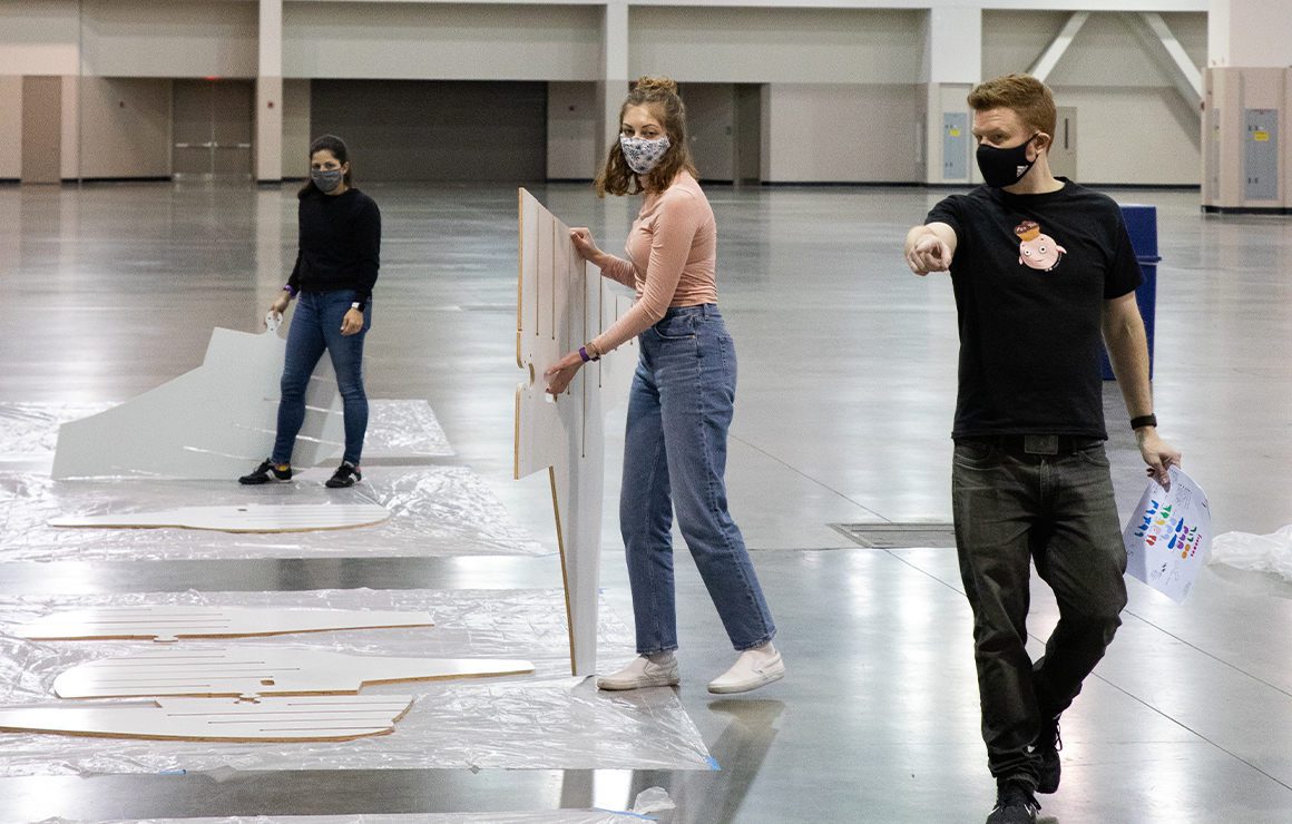 Artists assembling Massimals in a warehouse.
