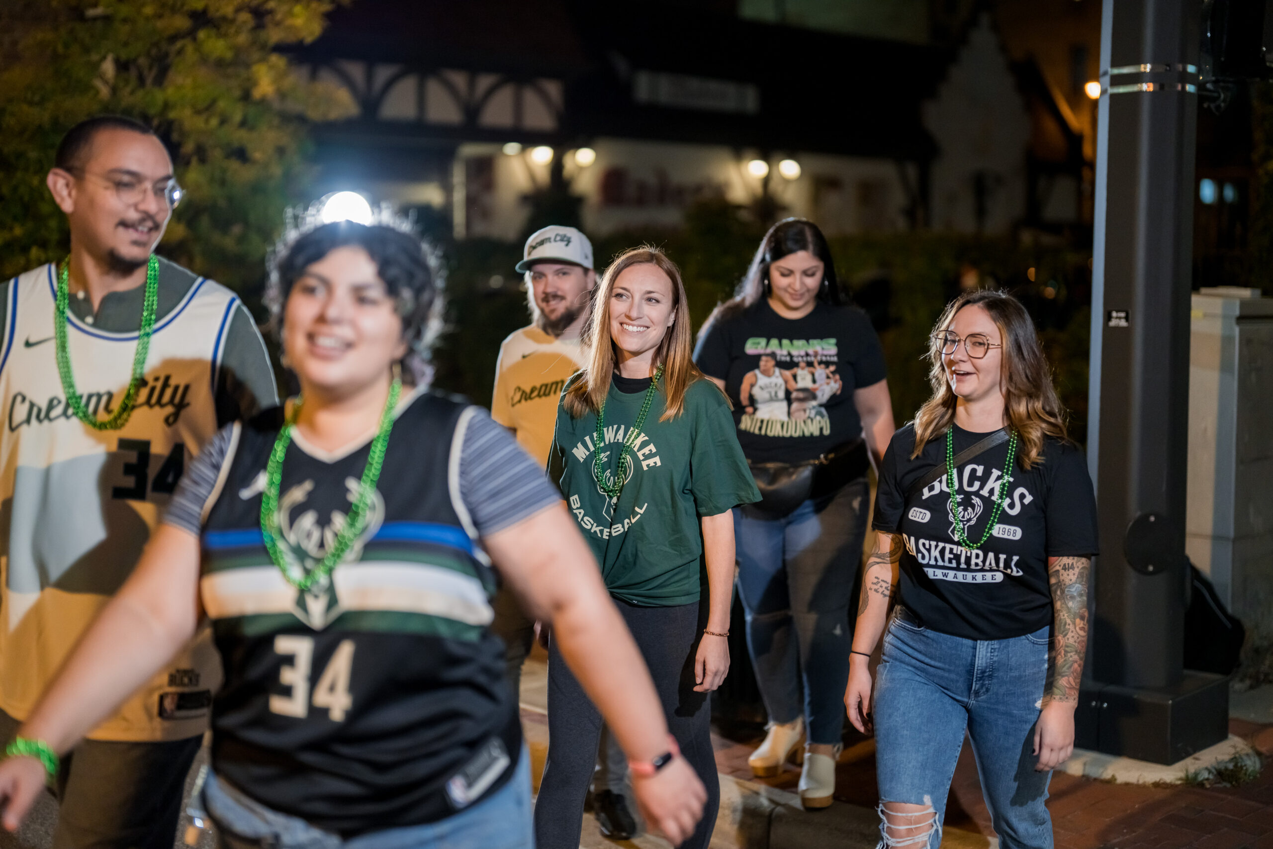 A group of Milwaukee Bucks fans walking across the street.