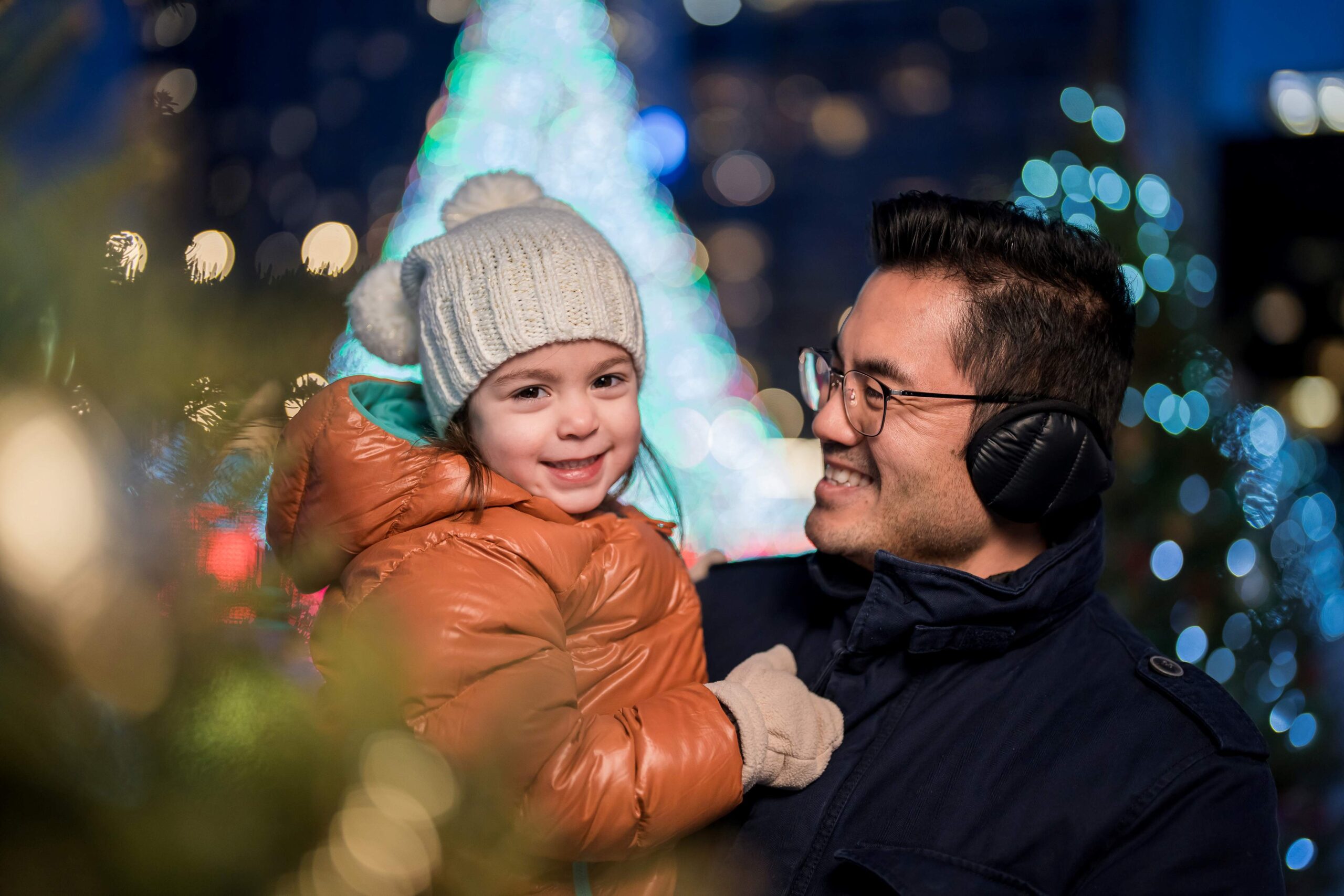 A father looking at his child during the Milwaukee Holiday Lights Festival event.