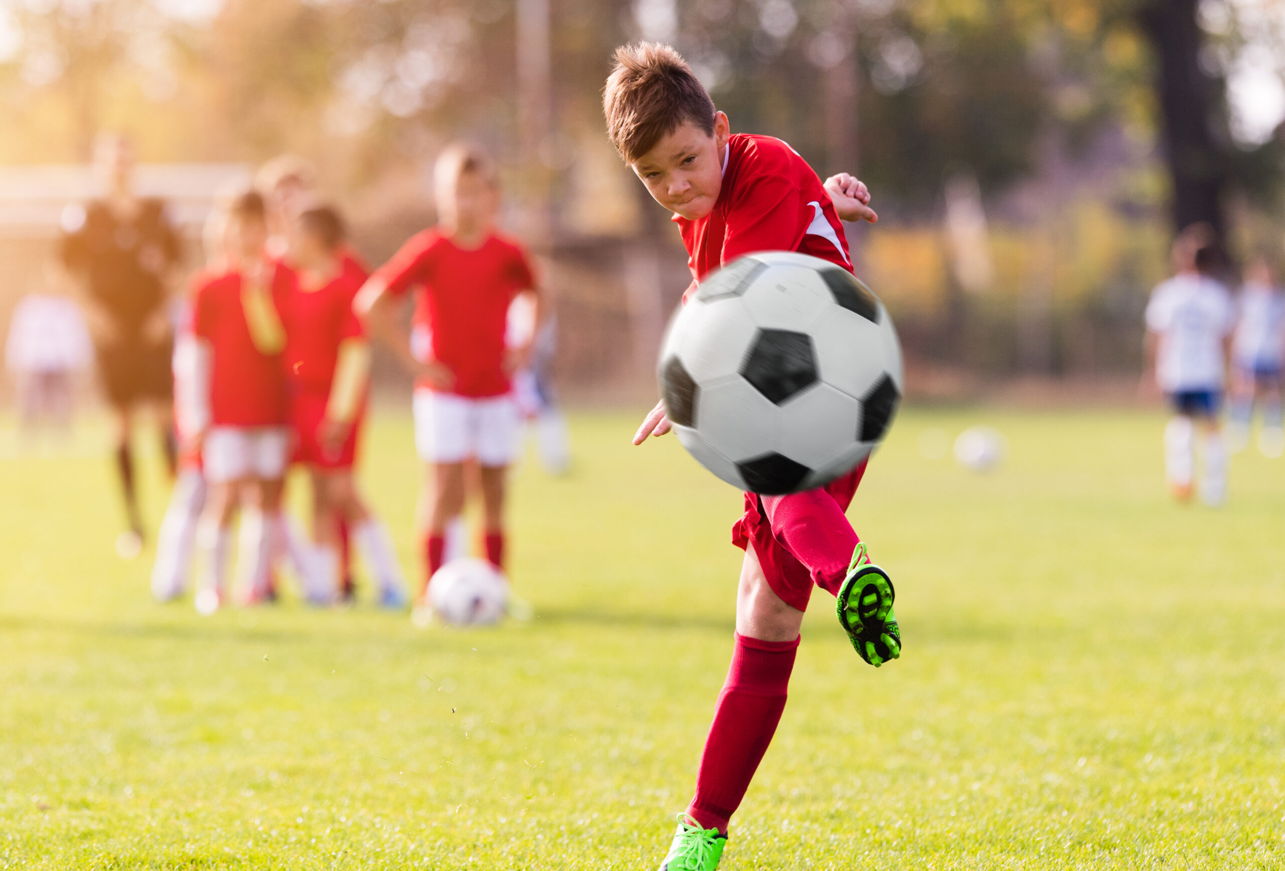 Boy,Kicking,Football,On,The,Sports,Field,During,Soccer,Match